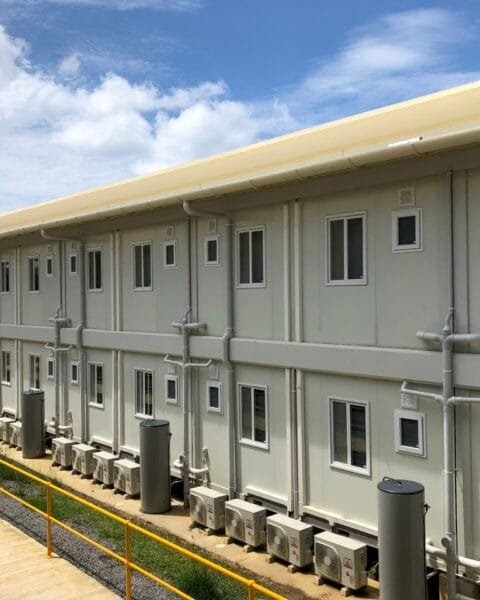 A row of white modular buildings featuring windows and balconies, showcasing modern Modular Construction Indonesia.