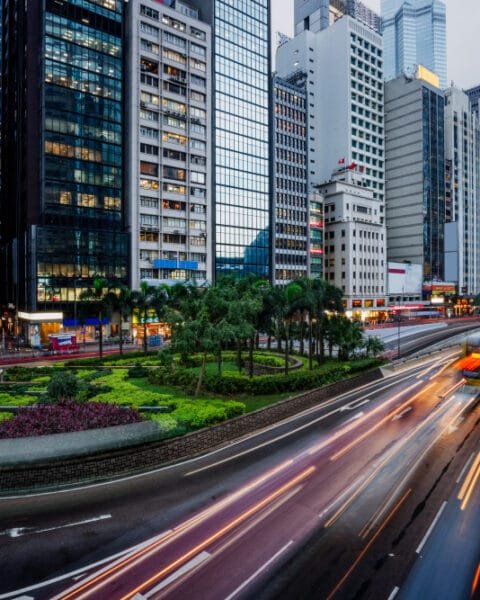 Cityscape with light trails on roads amidst high-rise buildings at dusk, representing the infrastructure and Public-Private Partnerships Indonesia.