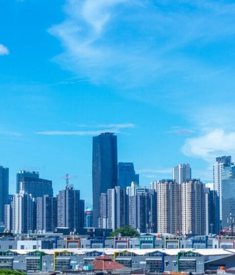 Scenic Jakarta cityscape with modern high-rise buildings under a blue sky with clouds, symbolising Indonesia Construction Market Outlook 2025.