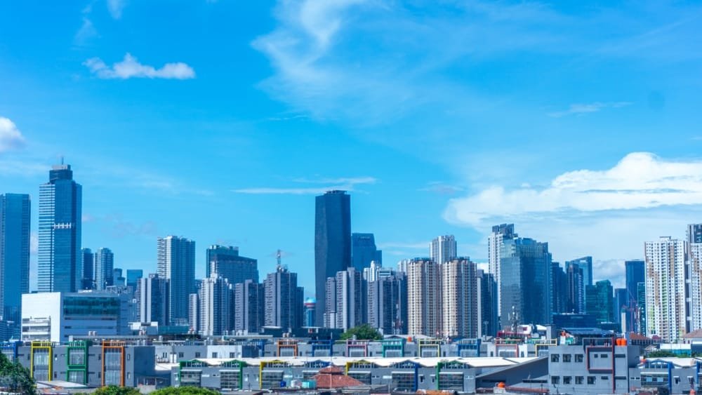 Scenic Jakarta cityscape with modern high-rise buildings under a blue sky with clouds, symbolising Indonesia Construction Market Outlook 2025.